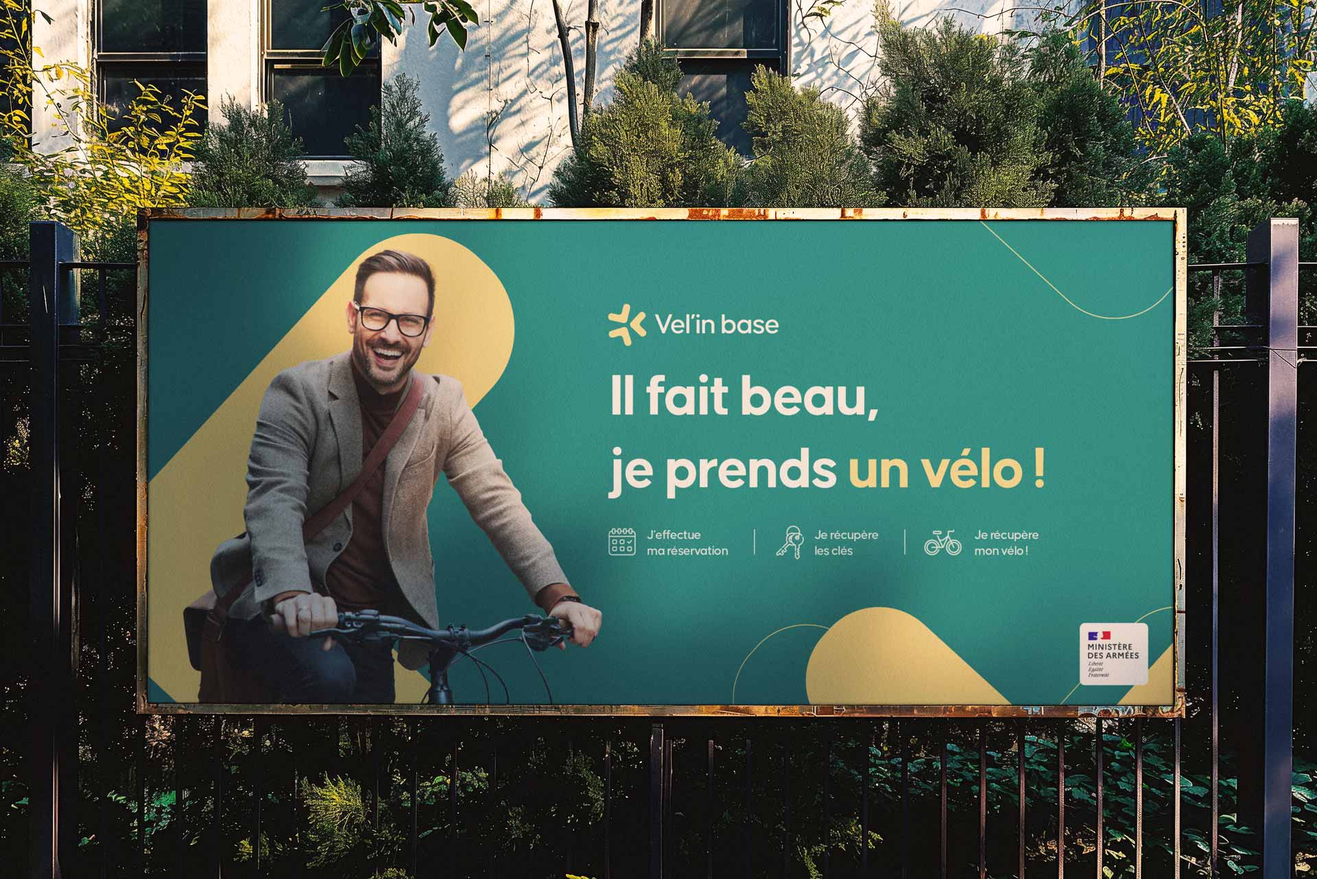 Affiche Vel'in Base avec un homme sur son vélo, le slogan 'Il fait beau, je prends mon vélo', et une charte graphique verte et jaune.