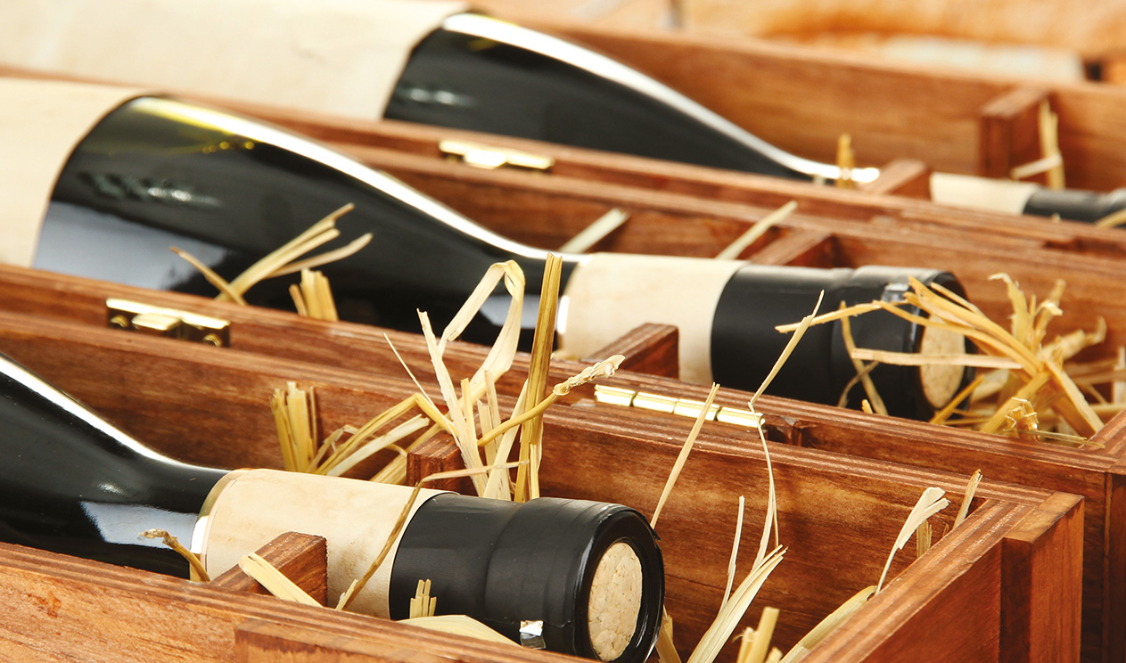 Bouteilles de vin dans une boîte en bois avec de la paille pour le projet Route des Vins.